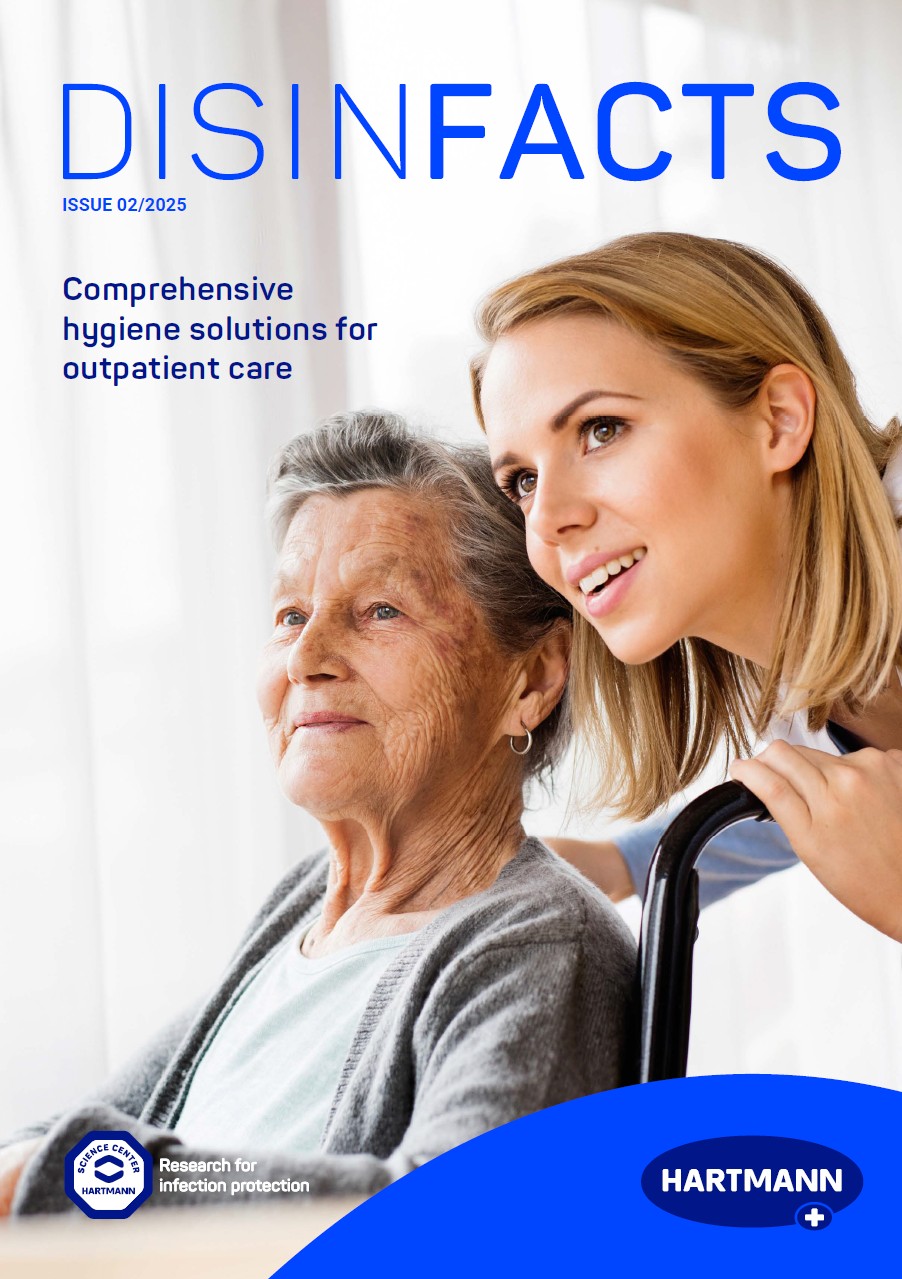 An elderly woman in a wheelchair and a younger woman who bends down attentively
