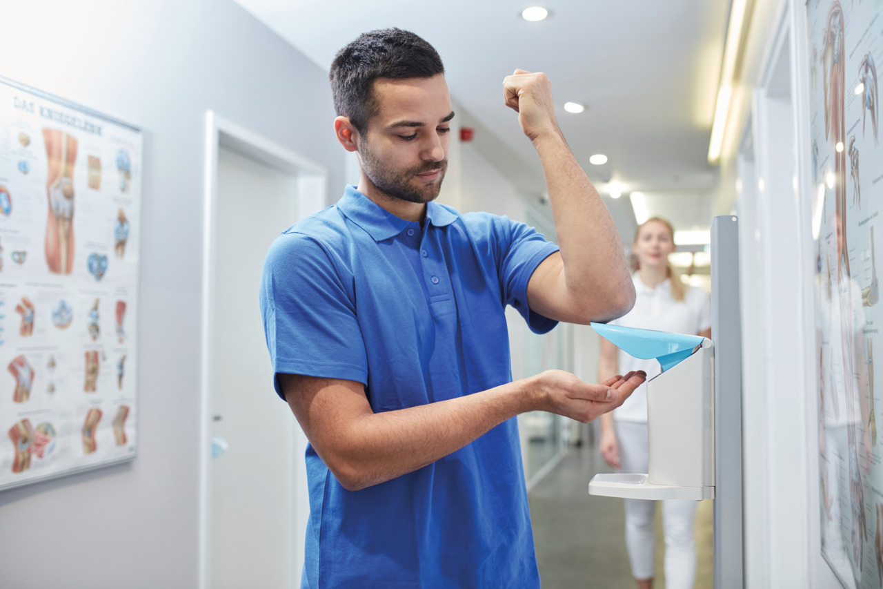 Hand disinfection nurse using Eurodispenser Safety plus in hallway