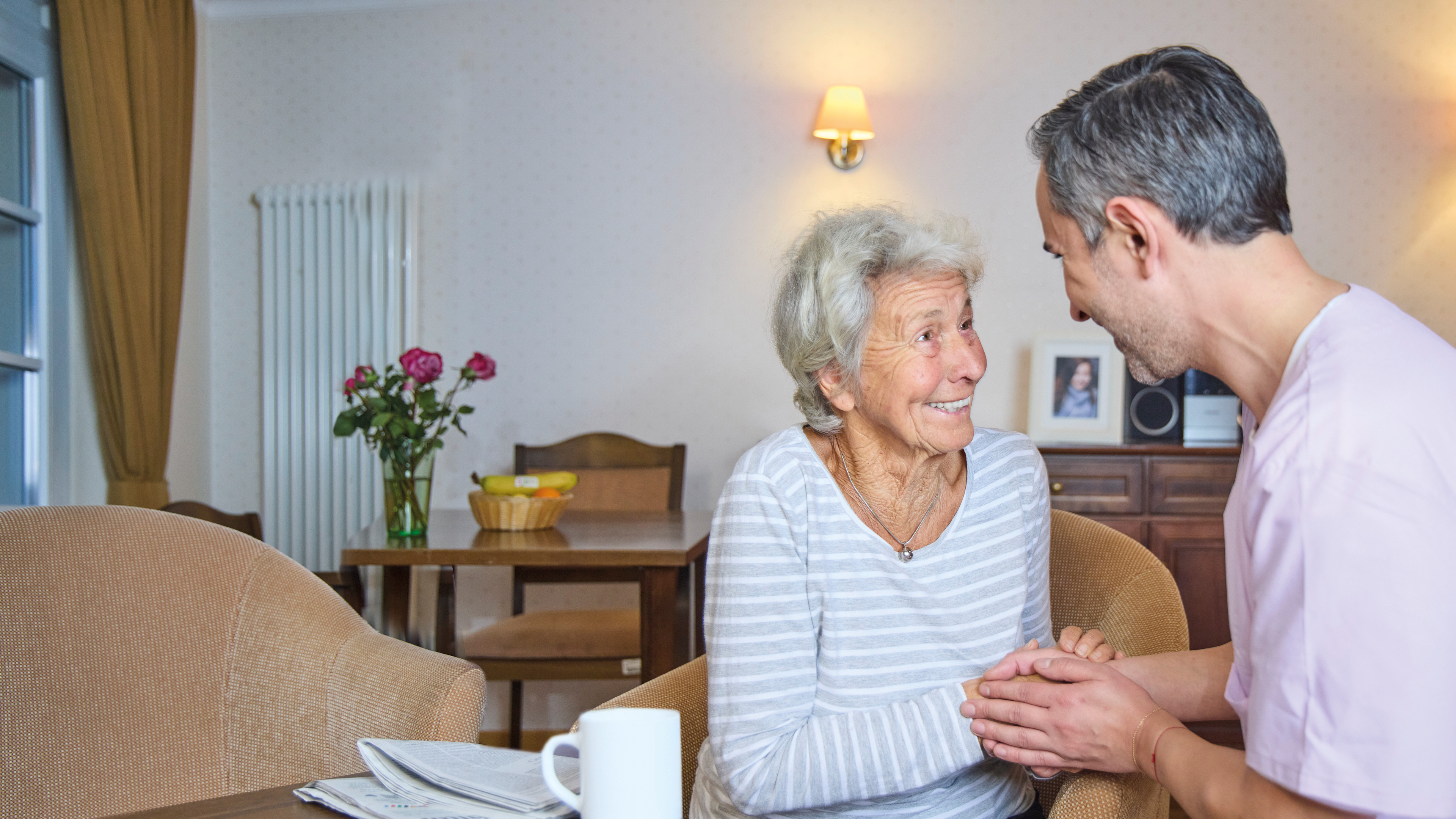 A healthcare worker in a nursing home caring about an elderly patient