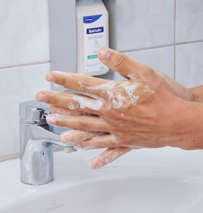 Hands washing hands in front of a soap
