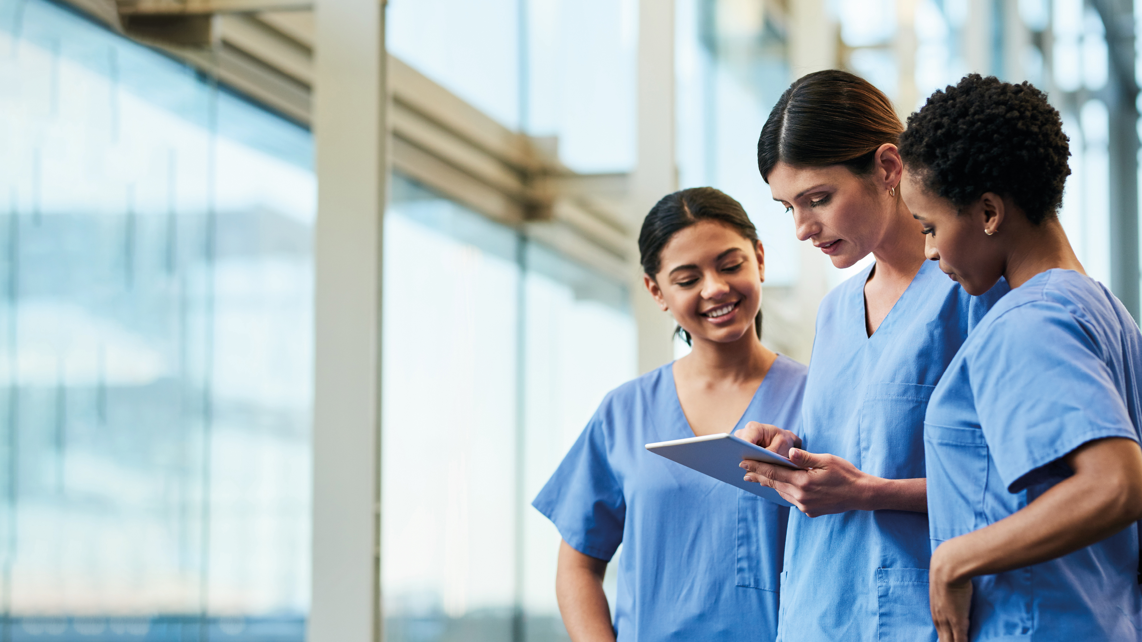 Three female nurses looking at a tablet