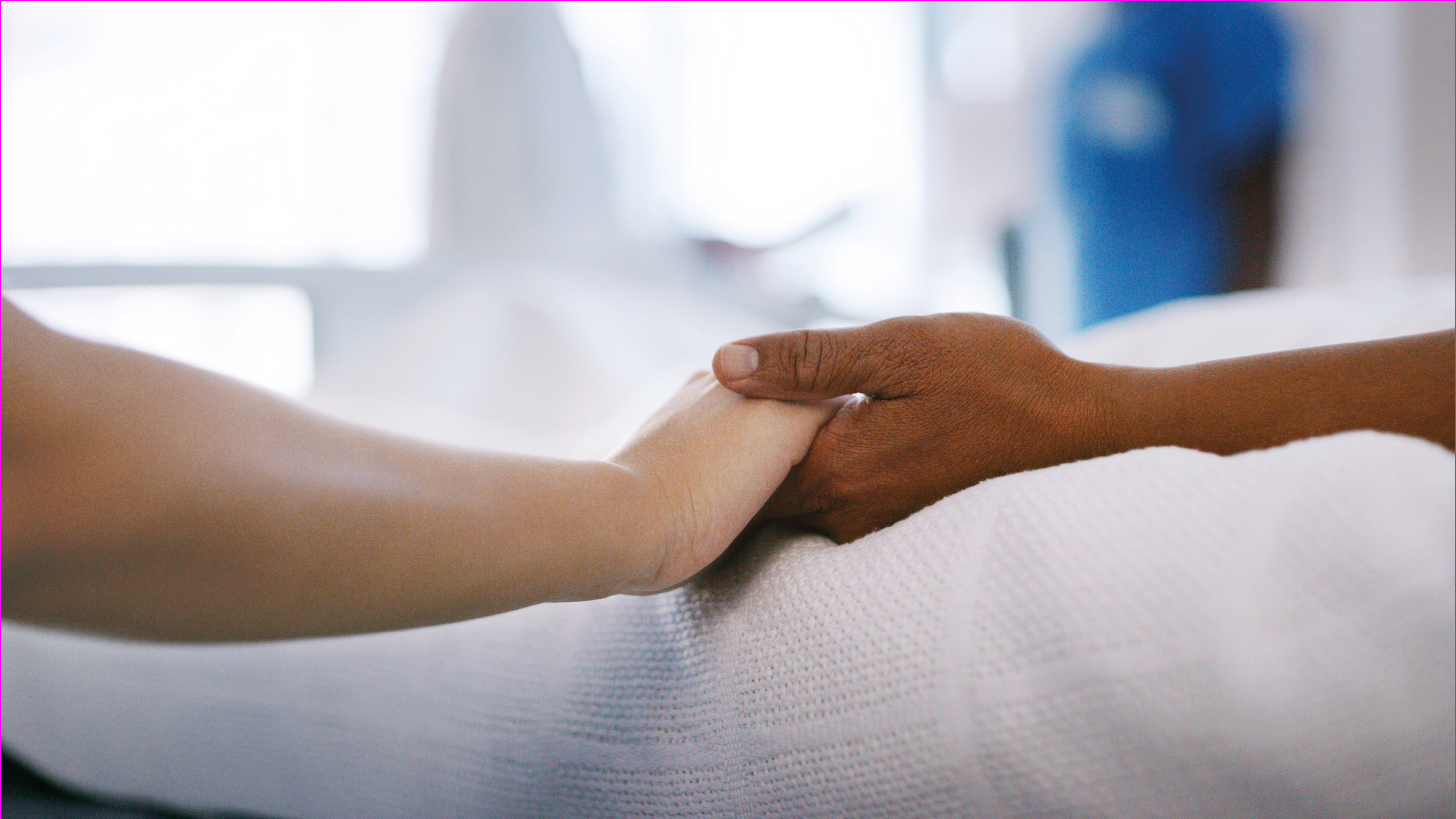 Two arms holding each other hands lying on a white underground.