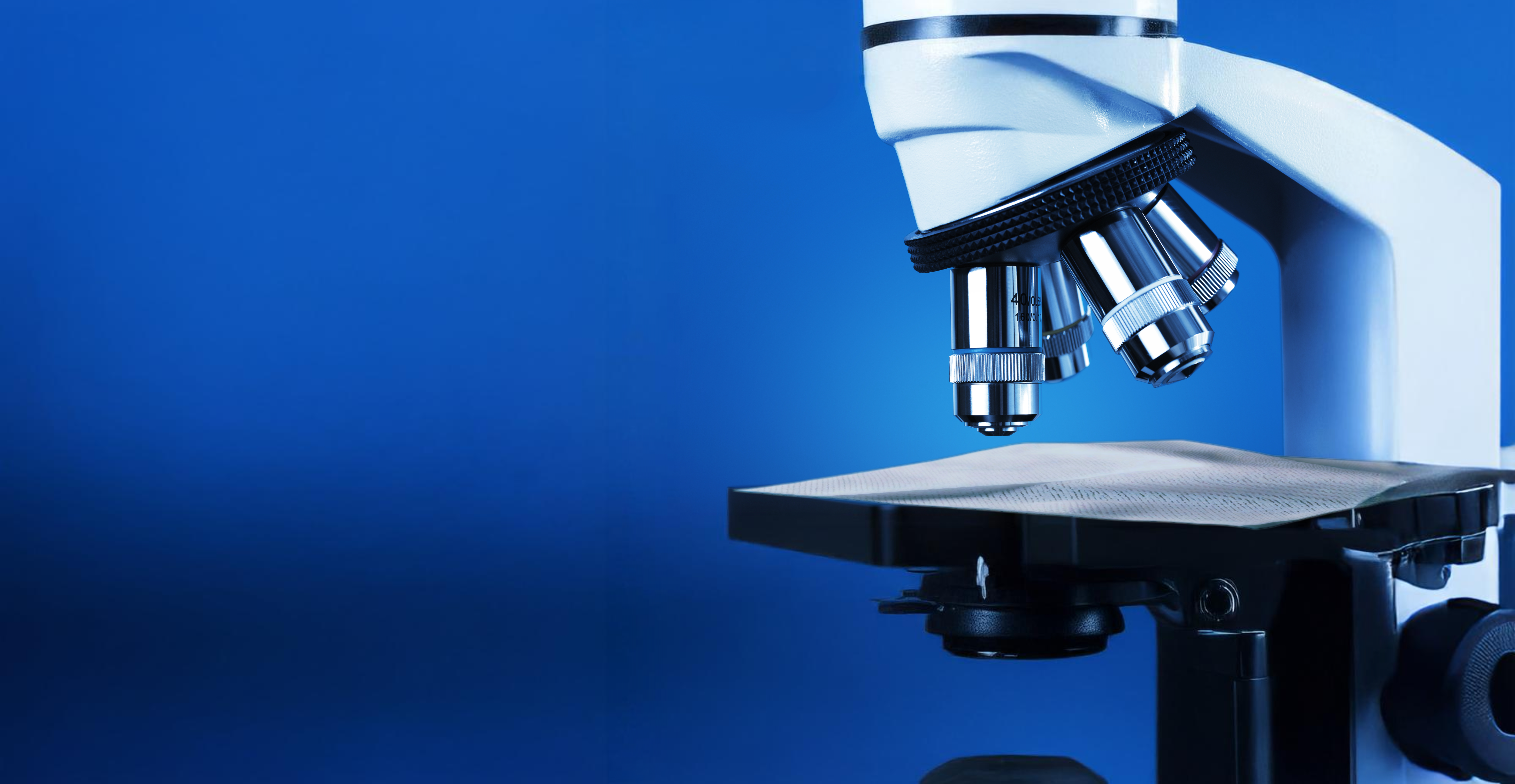 Close-up of a microscope with a disinfectant wipe under the lens