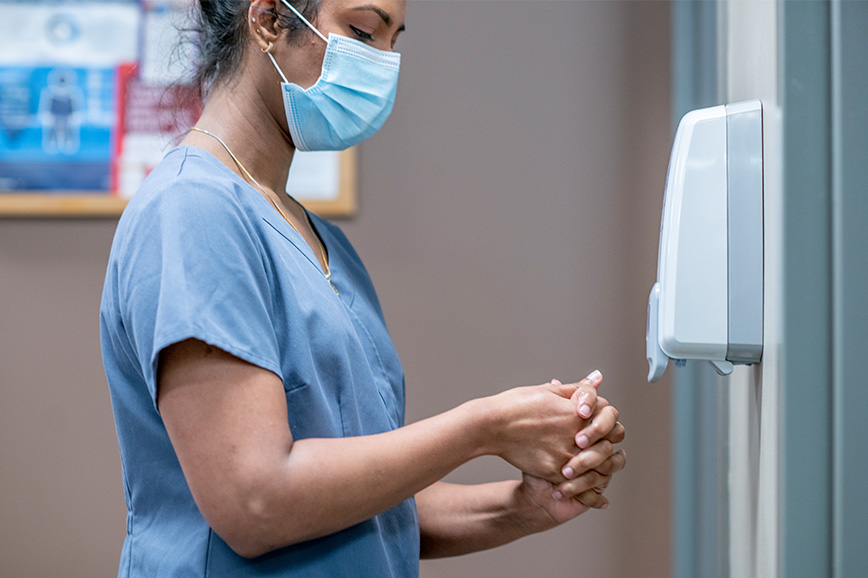 Health care professional disinfects her hands